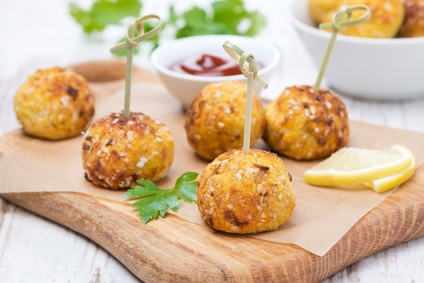 chicken meatballs in corn breading with tomato sauce on a board